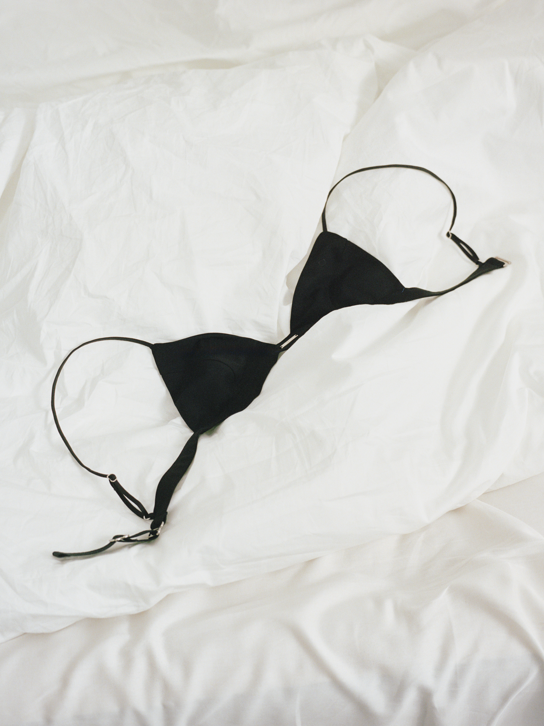 Black bikini top on a white textured surface