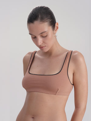 Woman wearing a beige underwear set on a white background