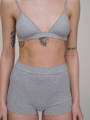A woman wearing grey melange high waist boxers and a matching bra. 