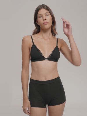 A woman wearing soft triangle bra and high waist boxers