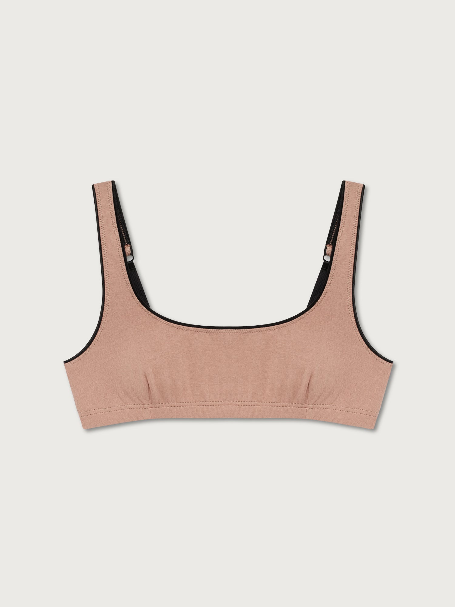 Beige underwear top with black trim on a light gray background